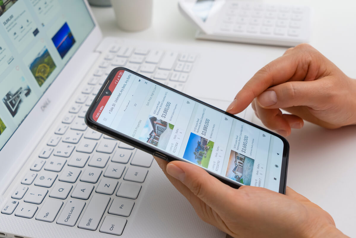 Man browses on mobile and a laptop